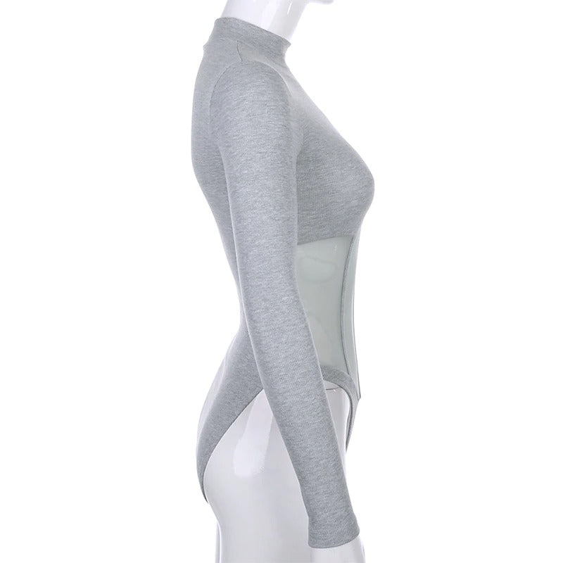 Side view of a women's gray mesh patchwork bodysuit with long sleeves and see-through design.