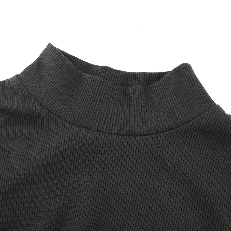 Close-up of a black turtleneck bodysuit showcasing textured ribbed fabric and modern neck design.