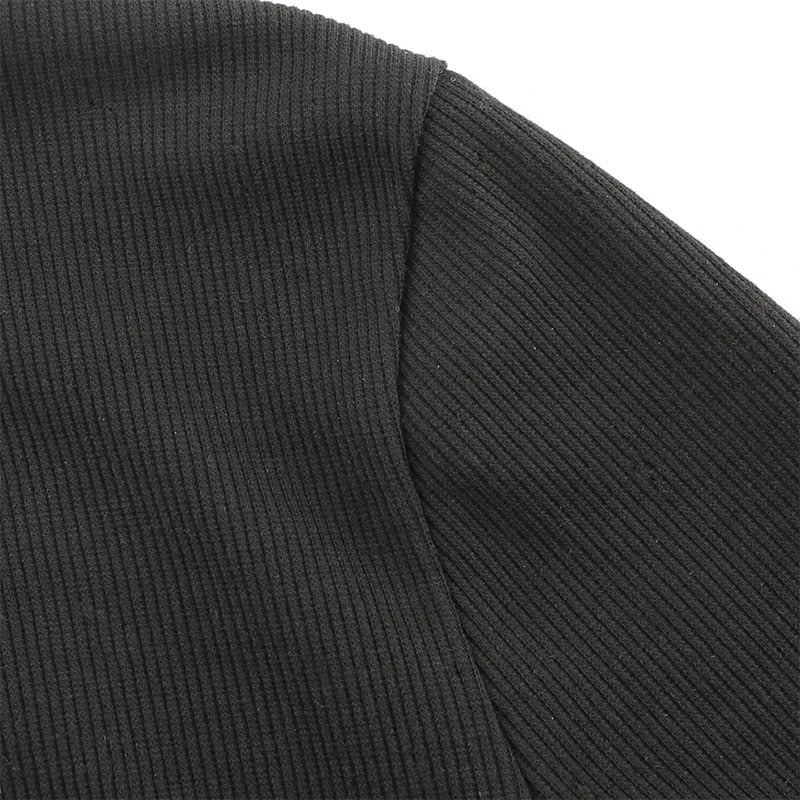 Close-up of dark ribbed fabric showcasing the texture of a stylish long-sleeve bodysuit.