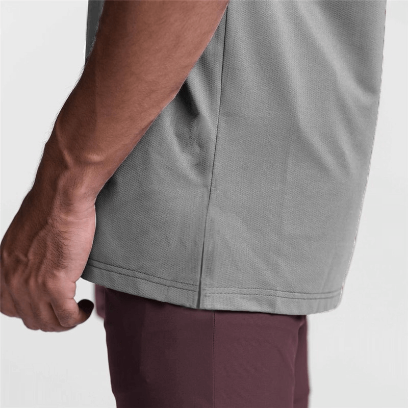 Close-up of a man's hand on the side of a gray mesh tank top, showcasing its comfortable fit and quality fabric.
