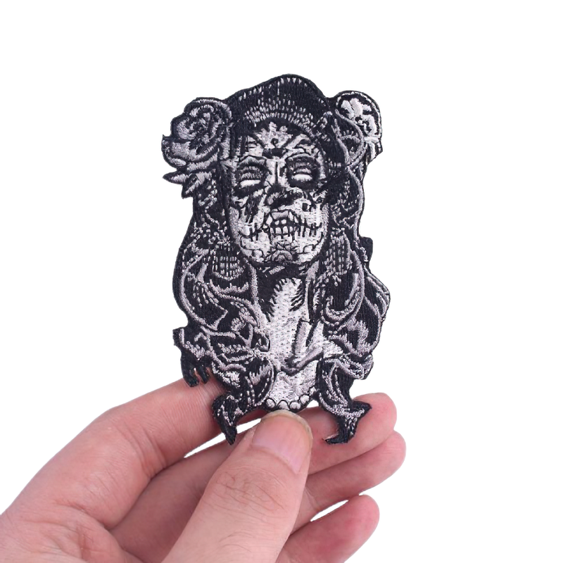 Gothic Mexican Day Of The Dead embroidered patch featuring a skull design, held in a hand.
