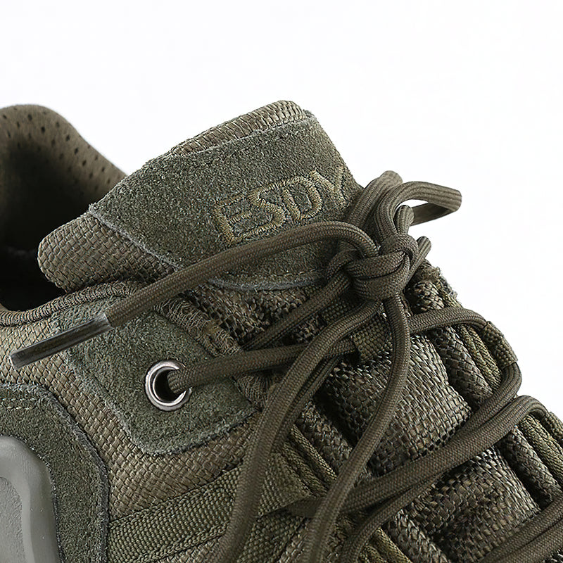 Close-up of military combat shoes in green with breathable mesh and durable laces, perfect for climbing and outdoor activities.