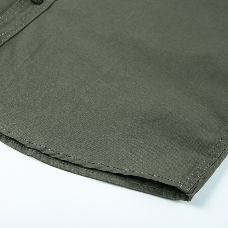 Close-up of olive green military style men's cotton shirt, featuring a stylish cut and durable fabric.