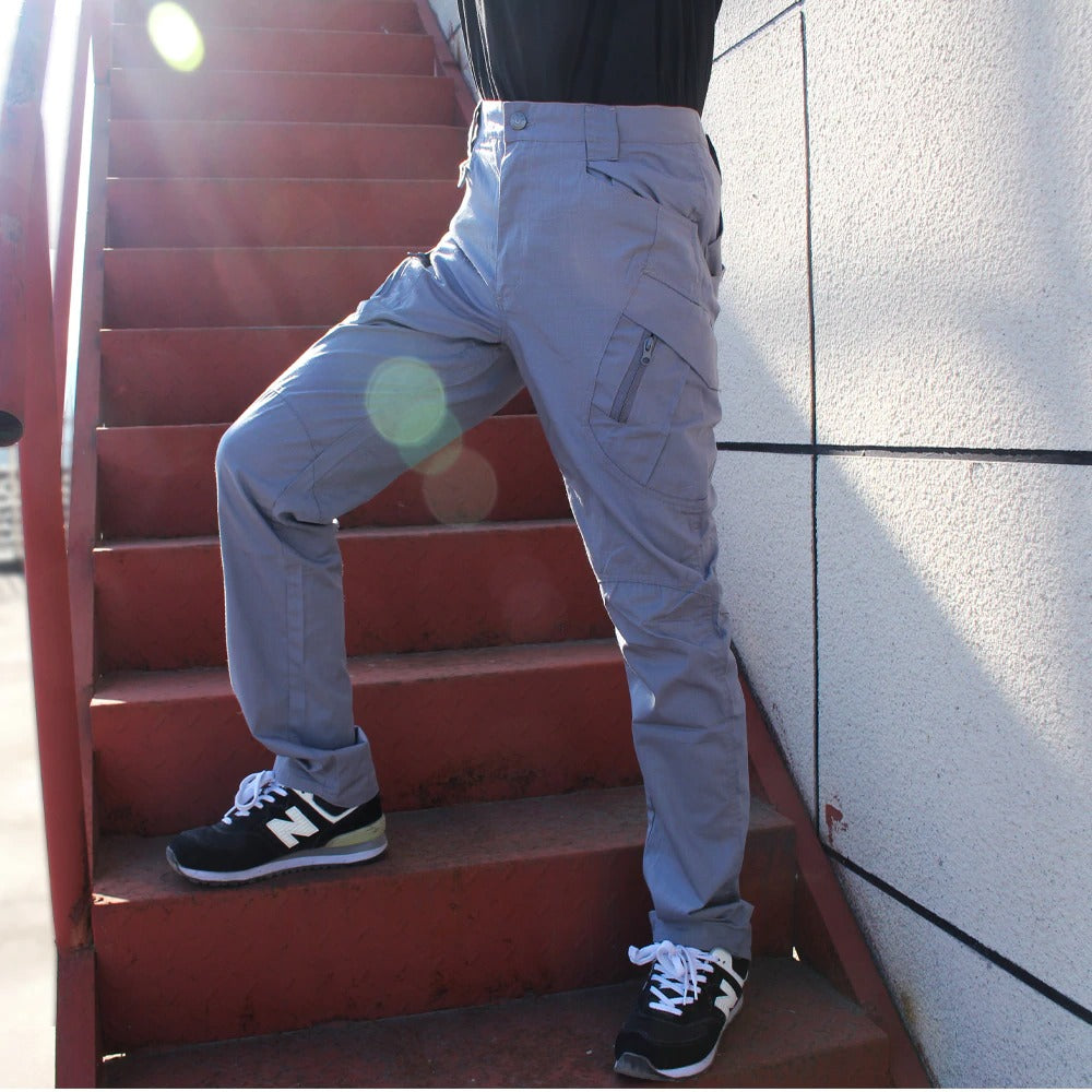 Men's military tactical cargo pants in gray, showcasing multiple pockets and a sleek design for outdoor adventures.