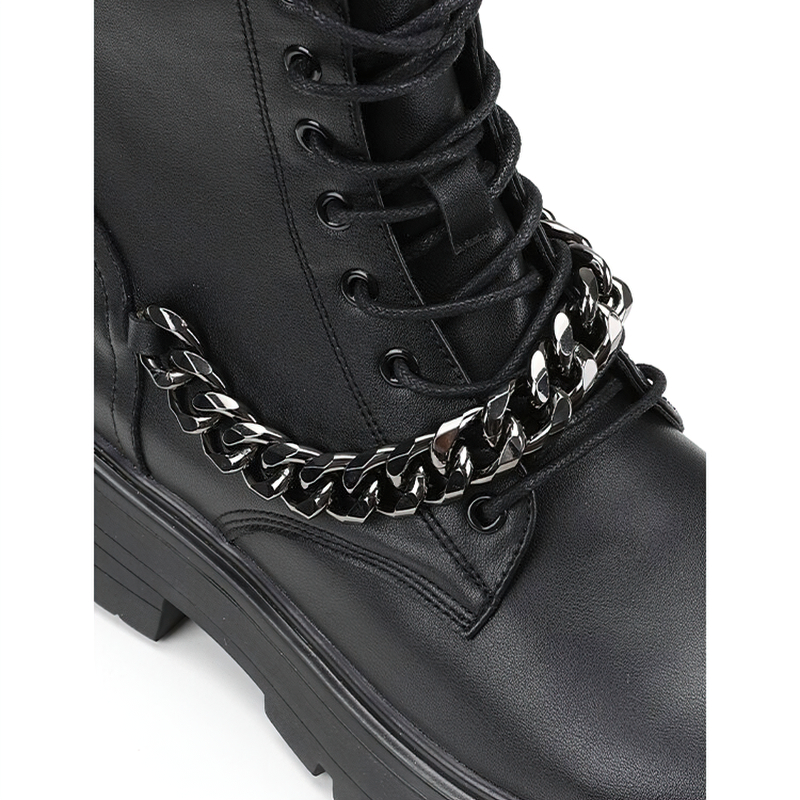 Close-up of black motorcycle boots featuring metal chain detail and thick sole for added style and comfort.