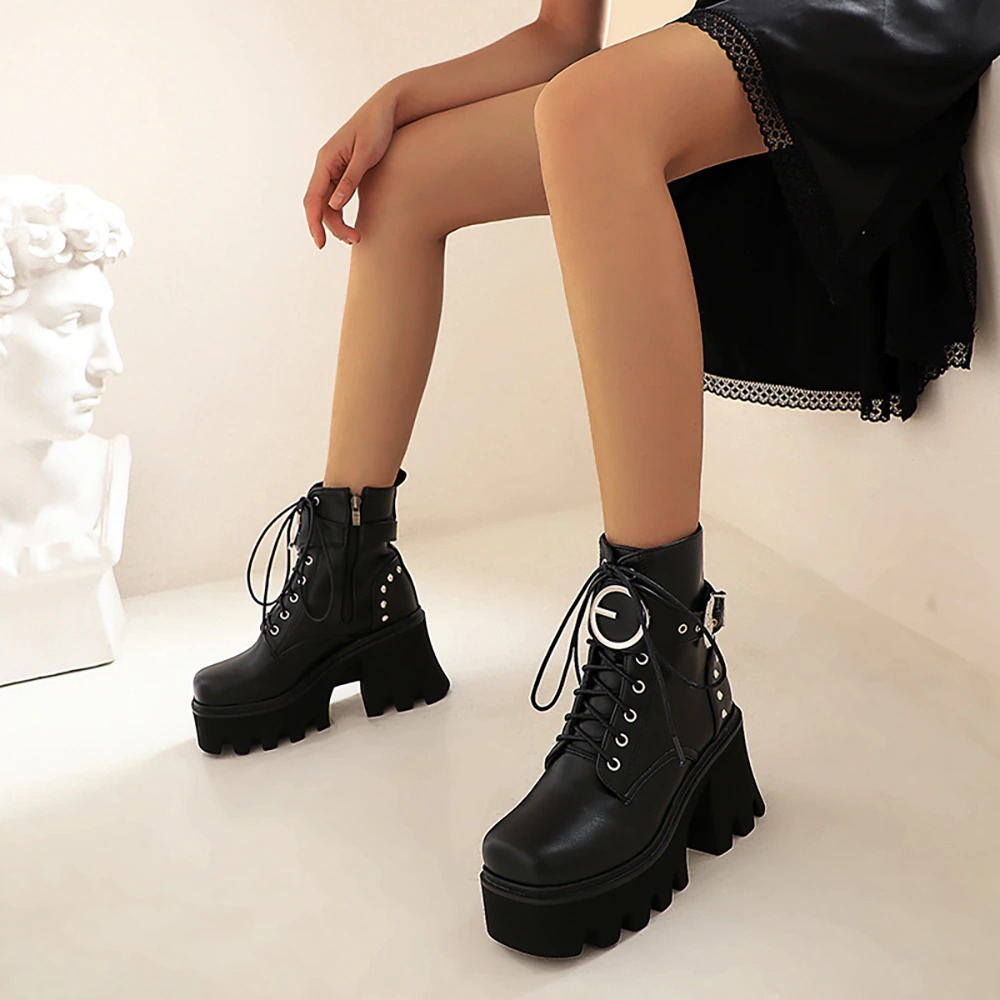Stylish black women's ankle boots with metal buckle and platform heels, perfect for casual outfits.