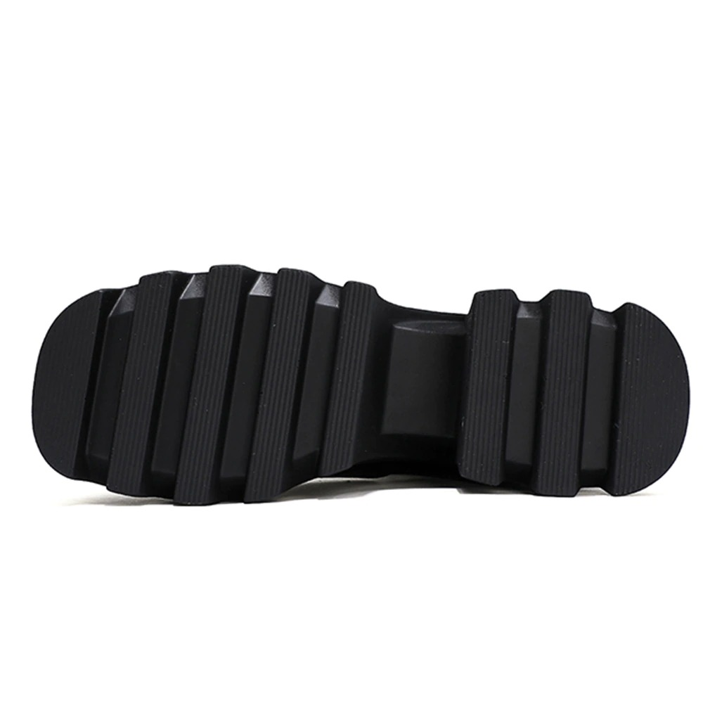 Black outsole of women's ankle boots showing rugged tread for enhanced traction and style.