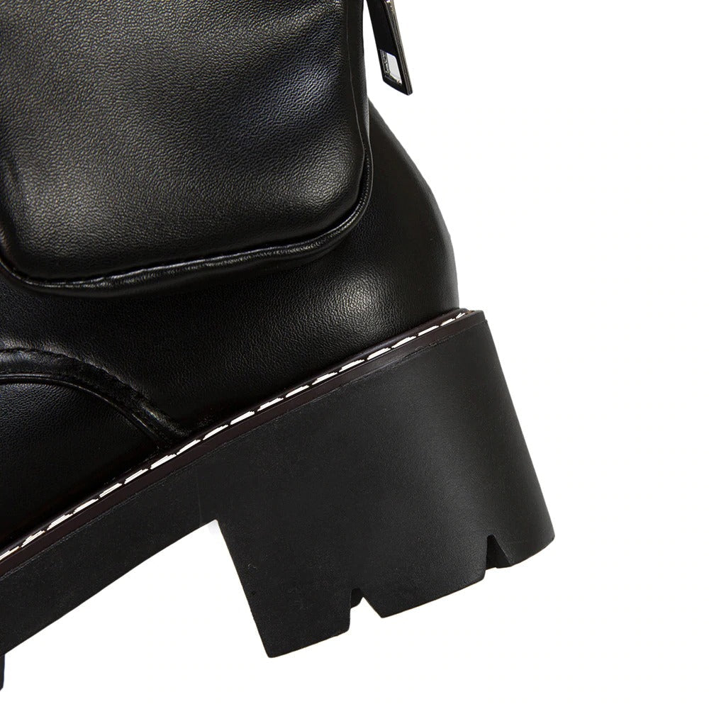 Close-up of black women's motorcycle boot showcasing thick sole, pocket detail, and stylish lacing for a steampunk look.