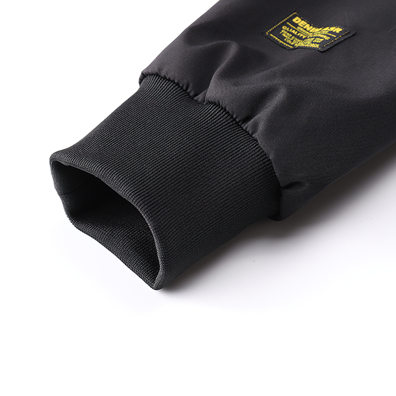 Close-up of the cuff and label of a multi-pocket cargo bomber jacket for men in black.