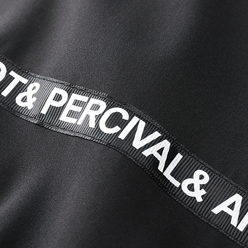 Close-up of a black bomber jacket featuring decorative text and branding on the fabric.