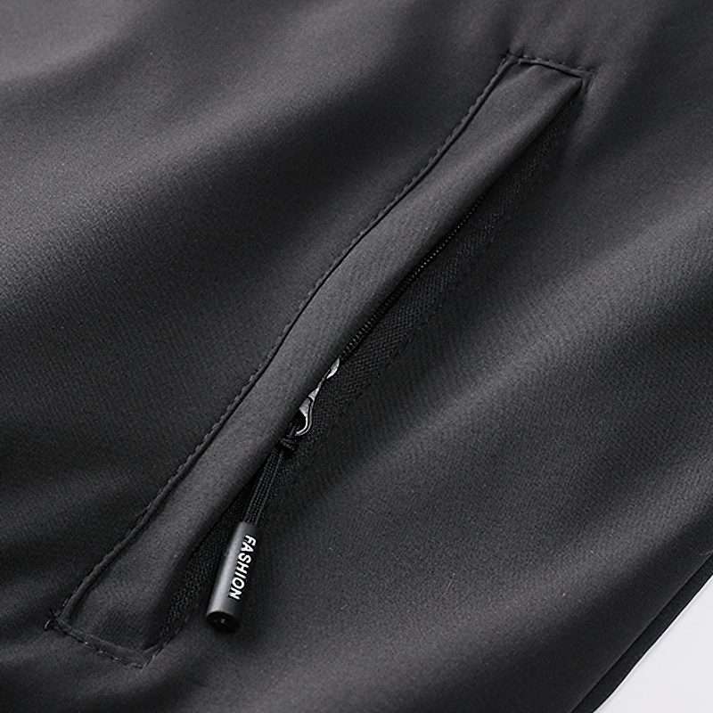 Close-up of the zippered pocket on a black multi-pocket cargo bomber jacket for men.