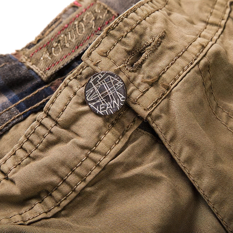 Close-up of the button and fabric details on multi-pocket men's cargo shorts in khaki.