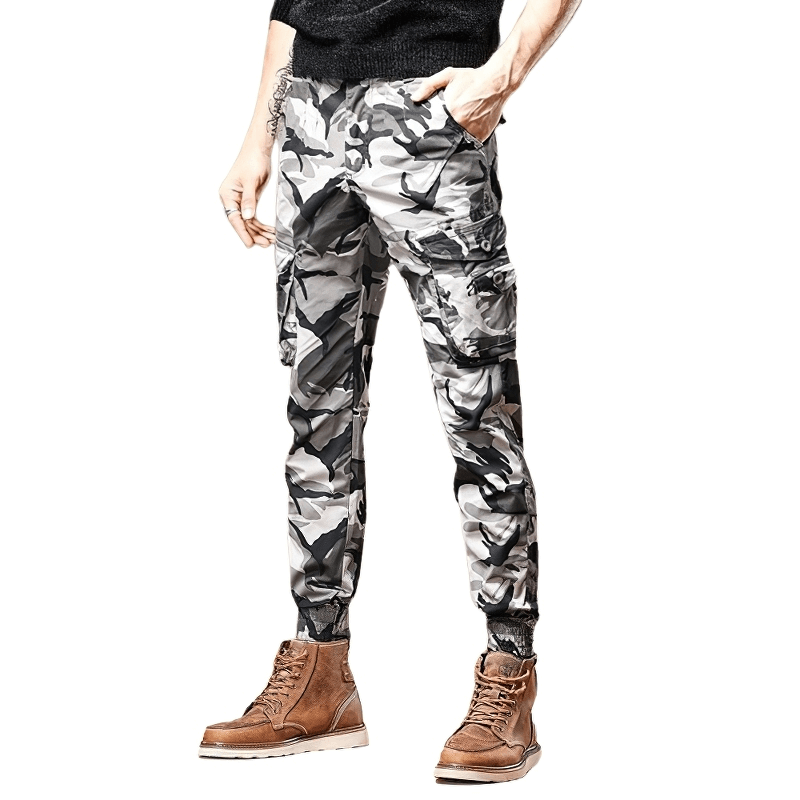Men's slim fit camouflage jeans in black and white pattern, styled with brown boots, highlighting casual military fashion.
