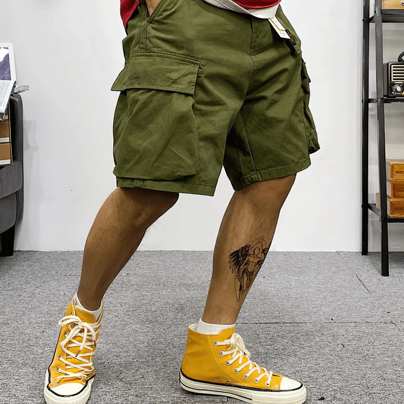 Men's cotton camouflage cargo shorts in olive green, stylishly paired with yellow sneakers, showcasing a relaxed alternative look.