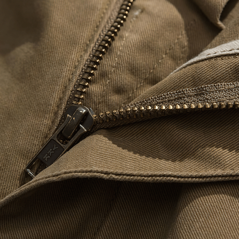 Close-up of a sturdy zipper on brown cotton cargo shorts, showcasing quality craftsmanship and attention to detail.