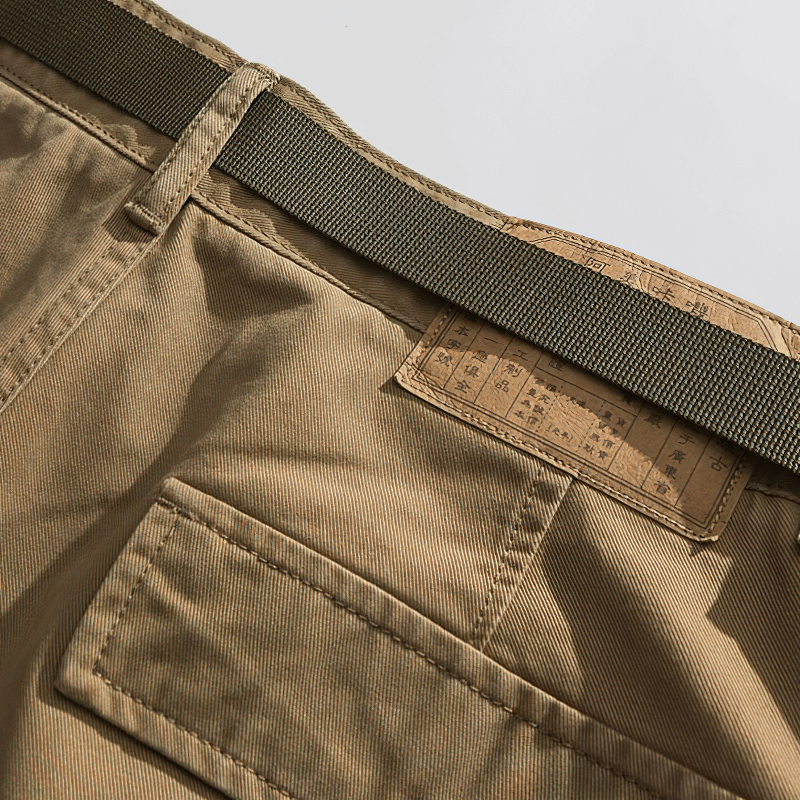 Close-up of multi-pocket military cargo shorts with a textured waistband and brand label, perfect for alternative fashion.