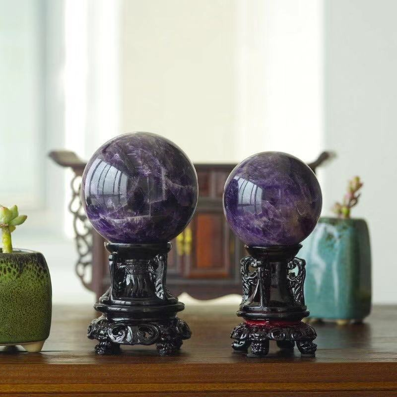 Elegant natural amethyst balls on decorative stands, perfect for home decor and enhancing your living space.