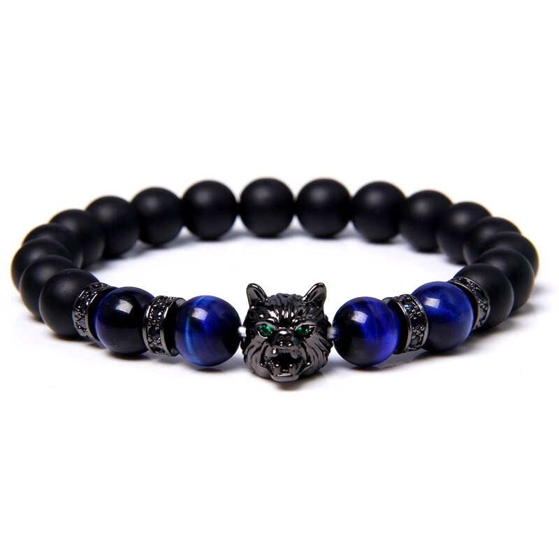 Natural black lava stone bracelet with wolf charm and blue beads, an alternative jewelry piece with animal symbolism.