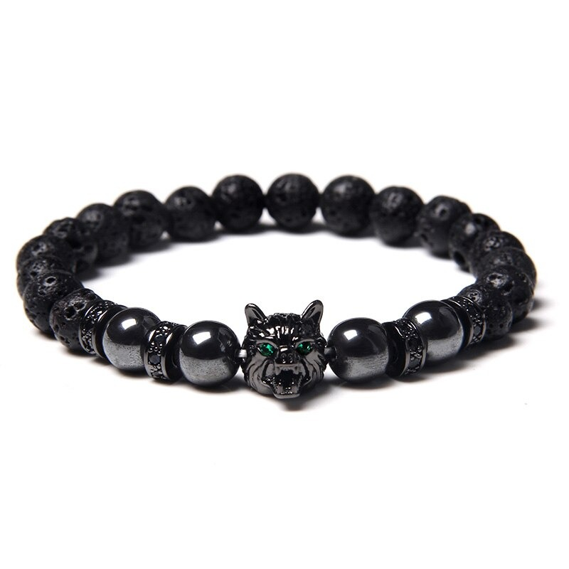 Natural black lava stone bracelet featuring a wolf charm with green eyes, perfect alternative jewelry for animal symbol lovers.