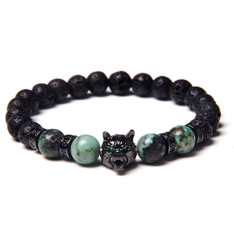 Natural black lava stone bracelet with wolf charm and green accent beads, perfect for alternative jewelry lovers.