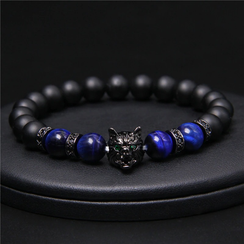 Natural black lava stone bracelet with wolf charm and vibrant blue beads, showcasing an alternative style and unique design.