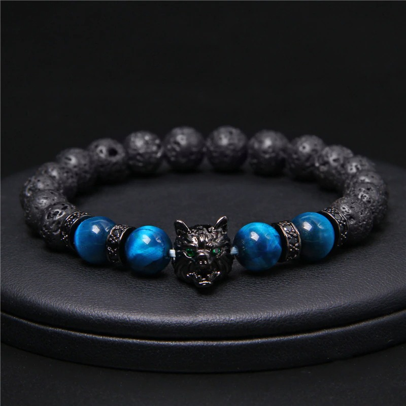 Natural black lava stone bracelet with wolf charm and blue beads, unique alternative jewelry with animal symbol.
