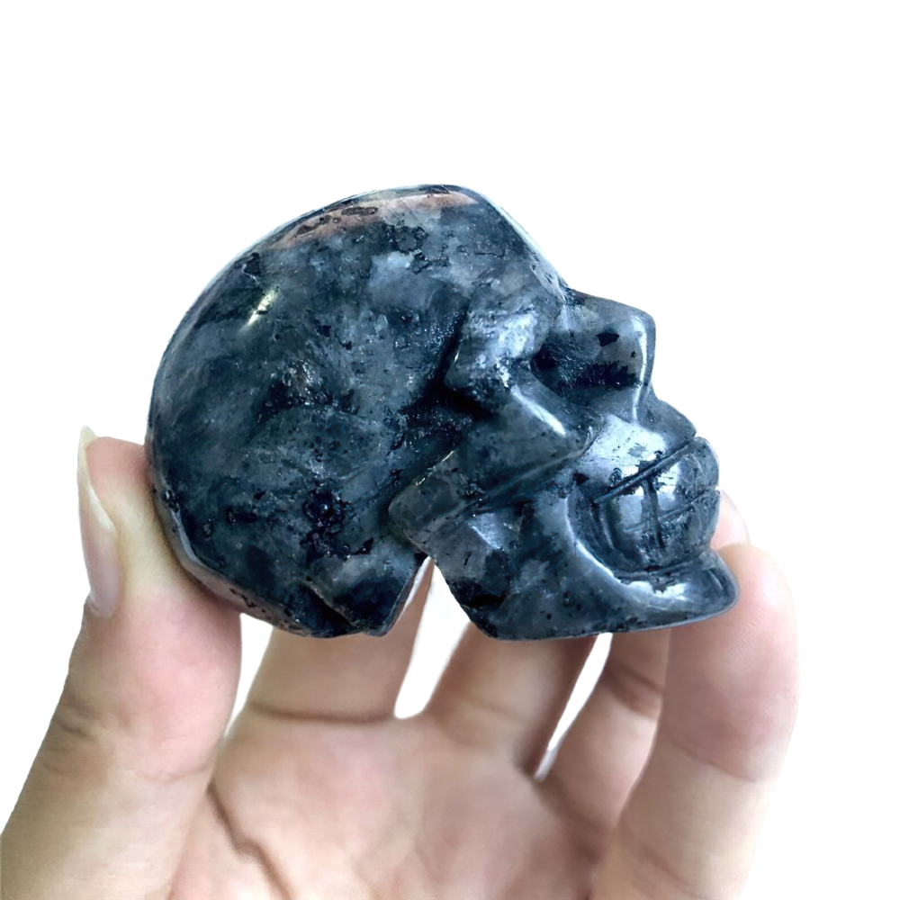 Hand holding a natural crystal skull, perfect for home decor and Wicca healing practices.