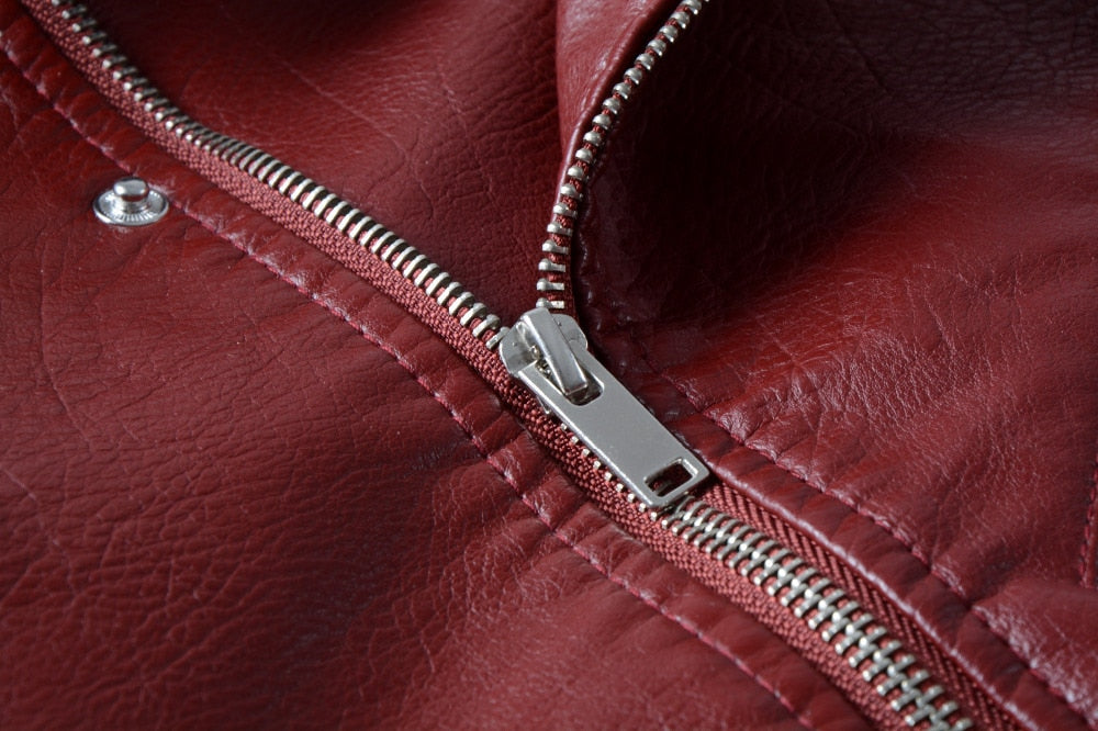 Close-up of a stylish red faux leather jacket zipper, showcasing alternative fashion details and unique design elements.