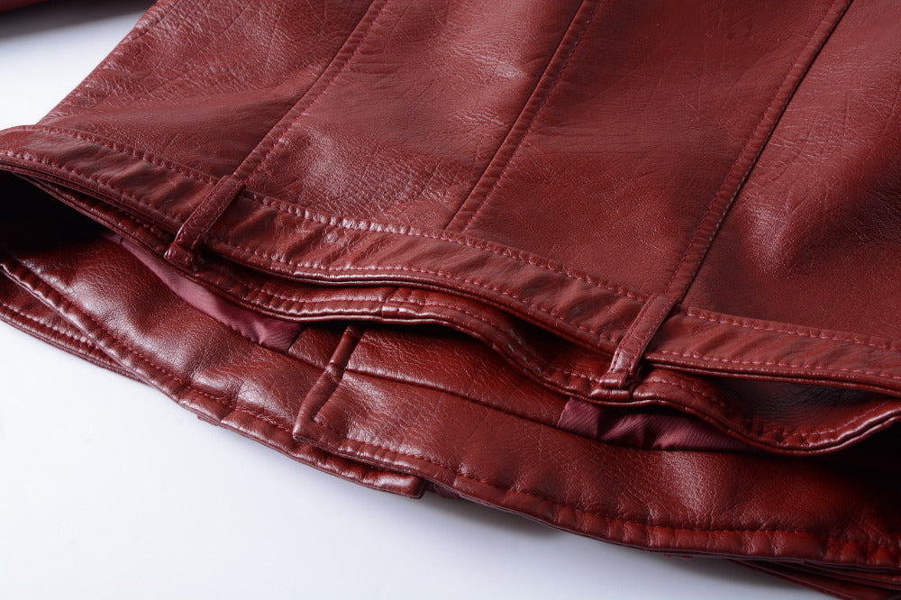 Close-up of a burgundy PU leather jacket hem featuring stylish stitching and a sleek inner lining.