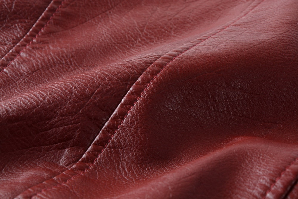 Close-up of rich red PU leather fabric showcasing its texture and detailed stitching for stylish alternative fashion.