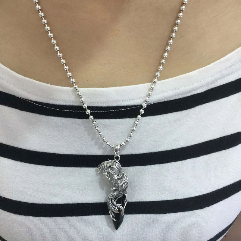 Unisex sterling silver phoenix pendant with black stone, worn on a striped shirt, perfect vintage fashion jewelry.