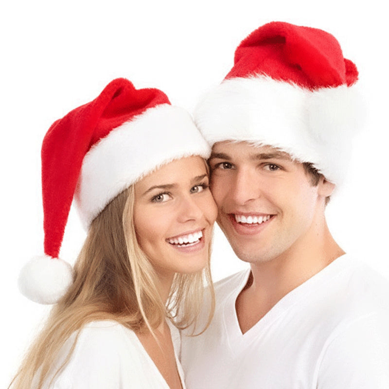 Two smiling adults wearing red plush Santa hats, celebrating the New Year in festive spirit.