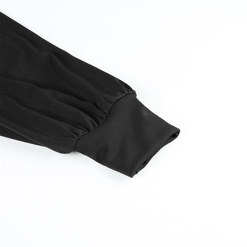 Close-up of the puffed sleeve cuff of a black off-shoulder top, highlighting the soft fabric and elegant design.