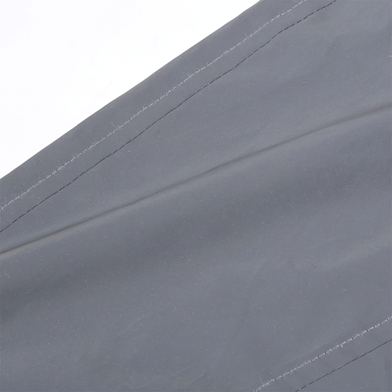 Close-up of the fabric texture of gray reflective outerwear, showcasing stitching details.