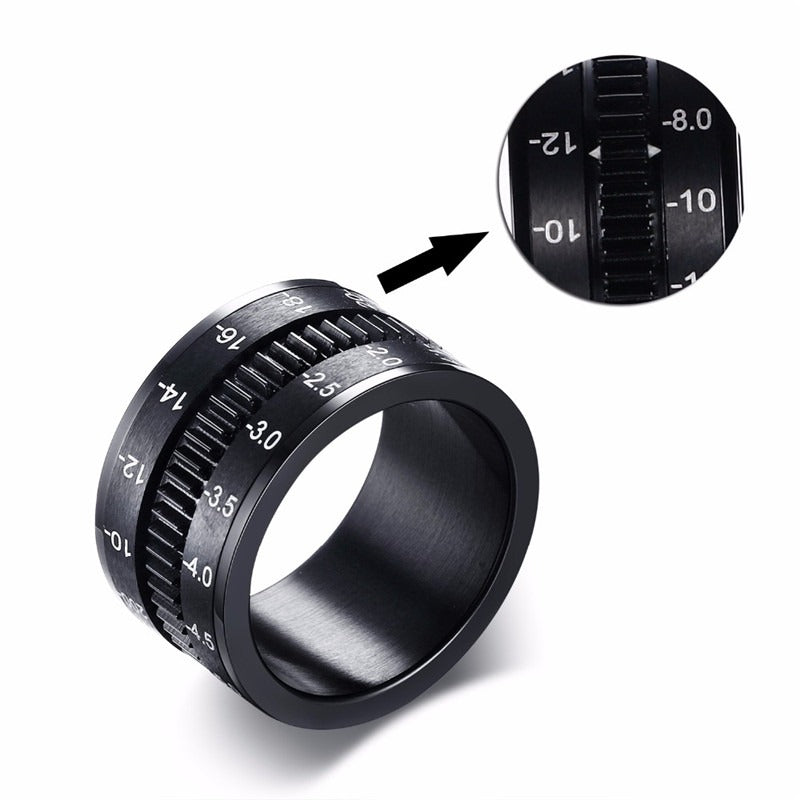 Stainless steel black camera lens ring with detailed markings, unique jewelry for photographers and camera enthusiasts.