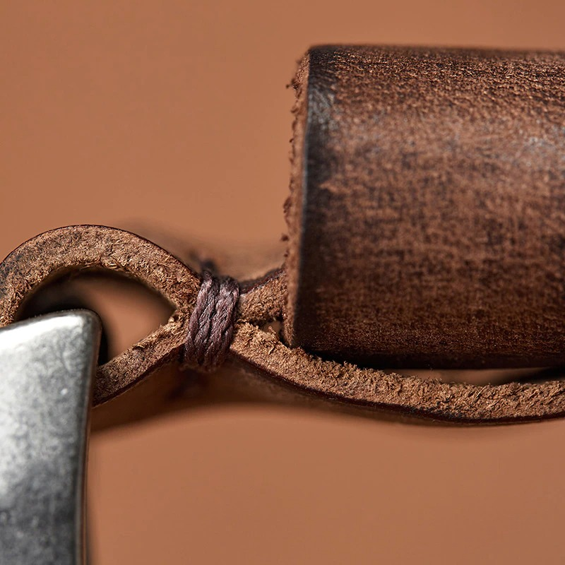 Close-up of a handmade cowhide belt with an alloy buckle, showcasing premium leather craftsmanship.