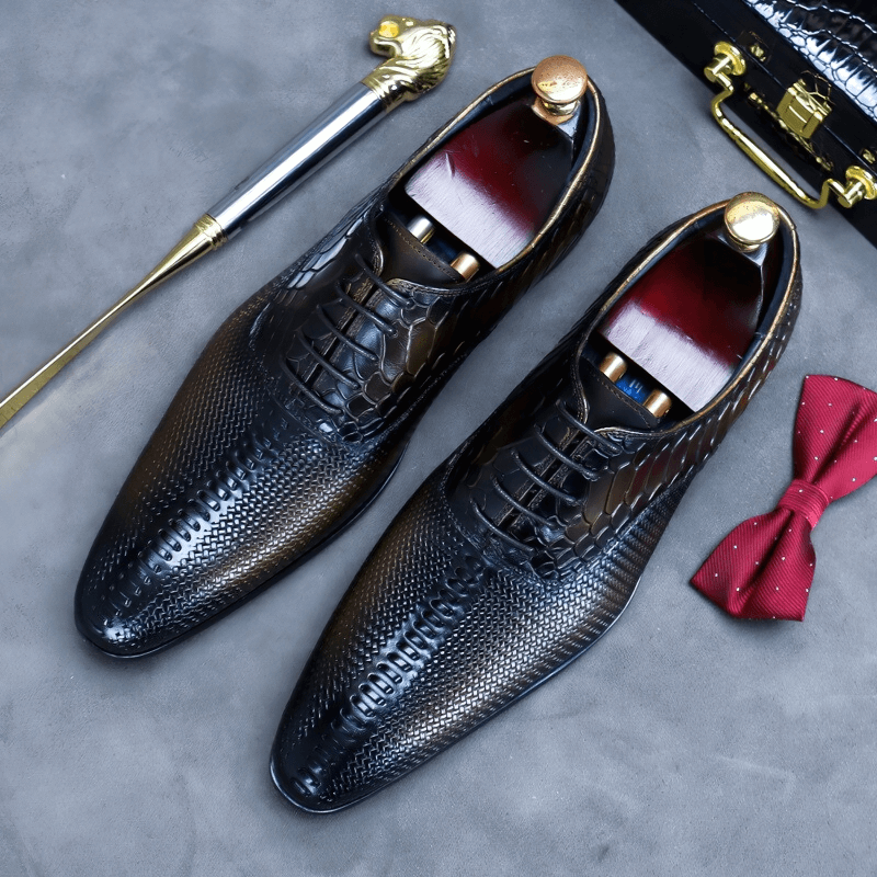 Luxury men's lace-up leather Oxford shoes with unique design, placed alongside a bow tie and elegant accessories.