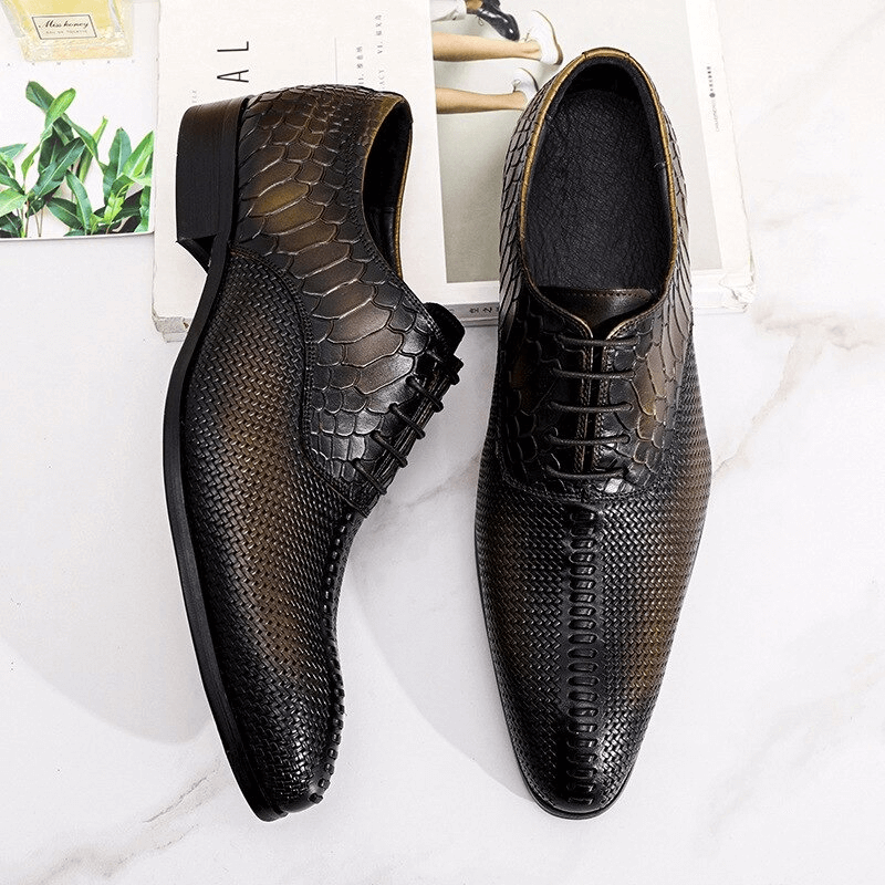 Stylish men's lace-up leather oxford shoes with a unique snake skin pattern on a bright background.