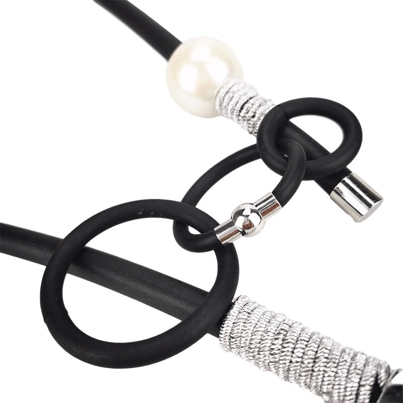 Close-up of a stylish women's necklace with removable details in black, silver, and pearl accents, showcasing punk vintage fashion.