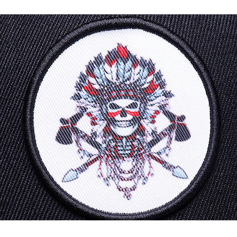 Embroidered patch featuring a colorful skeleton with feathers and axes, perfect for a stylish baseball cap.