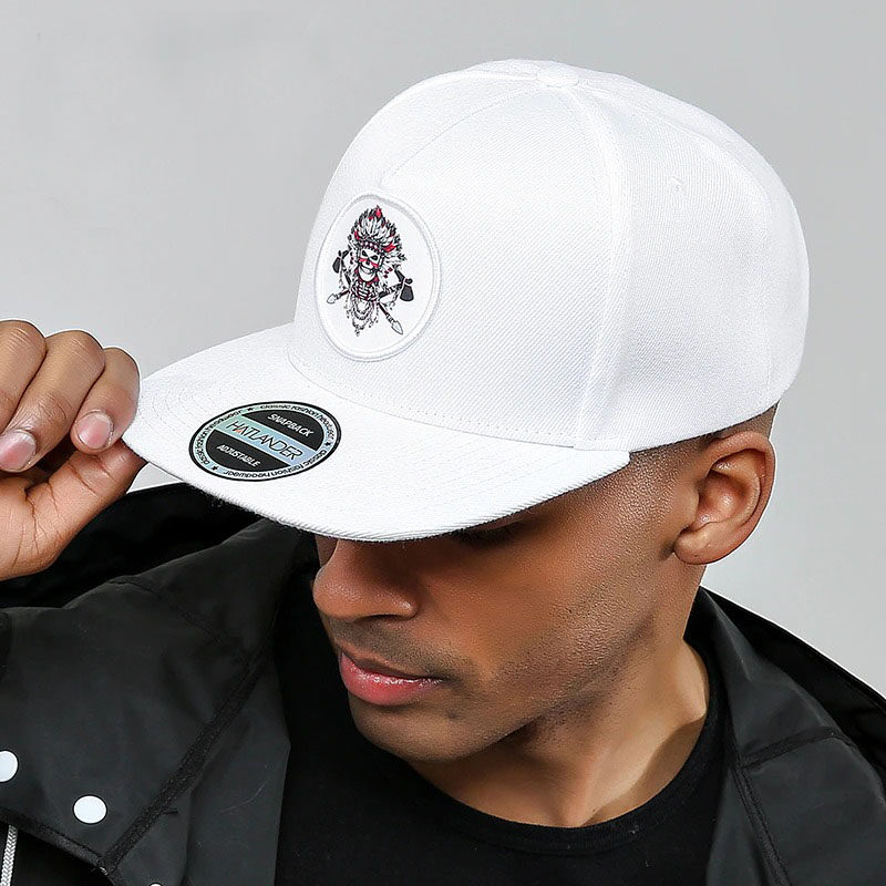 Stylish man wearing a white adjustable snapback baseball cap with embroidered skeleton design.