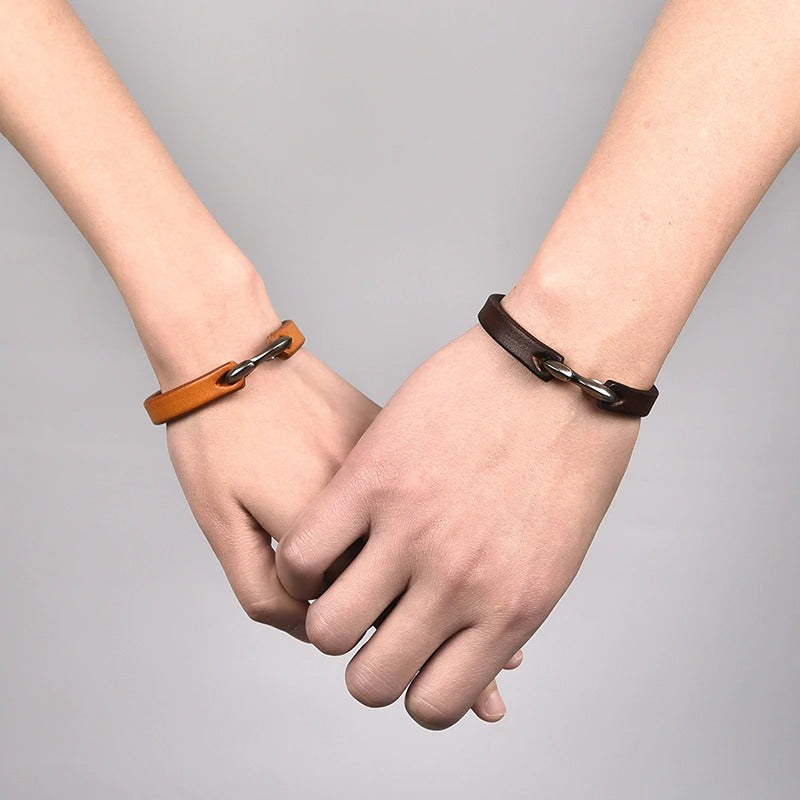 Unisex vintage leather bracelets in black and brown worn on hands, showcasing grunge style accessories.