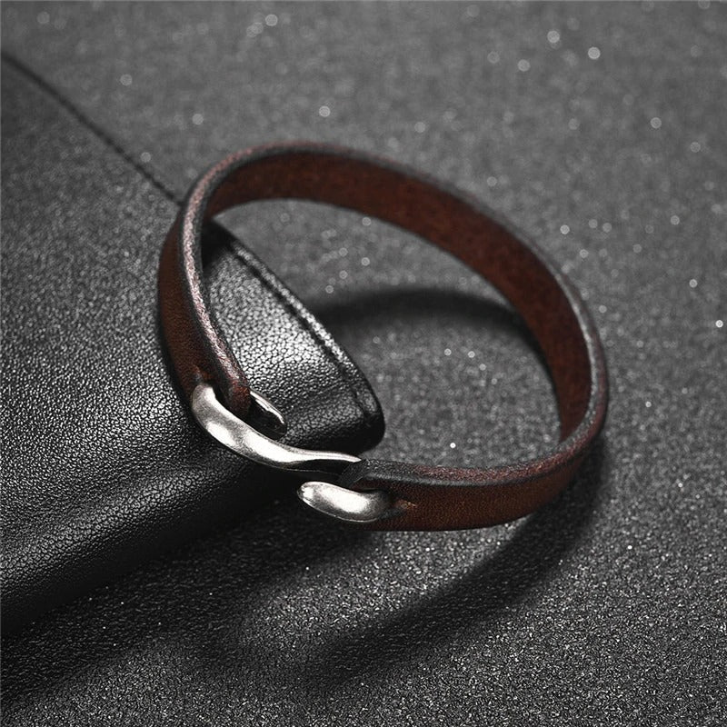 Vintage brown leather bracelet with silver clasp on textured background, perfect for grunge style outfits.