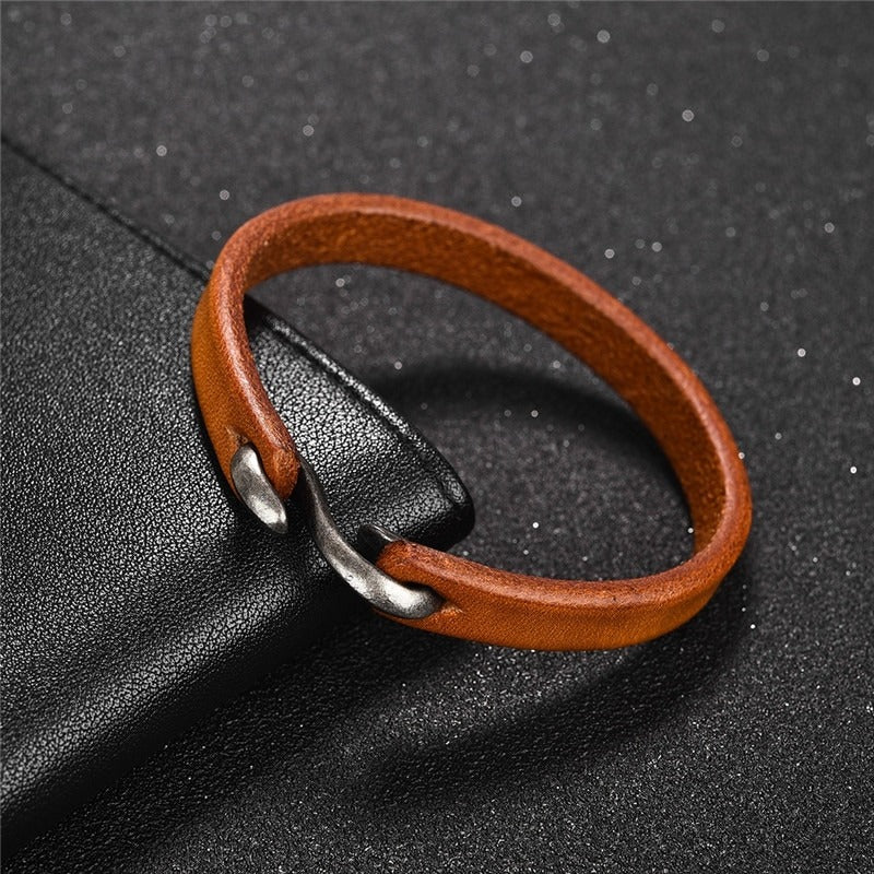 Vintage brown leather bracelet with copper alloy clasp on sleek black background, perfect for grunge outfits.