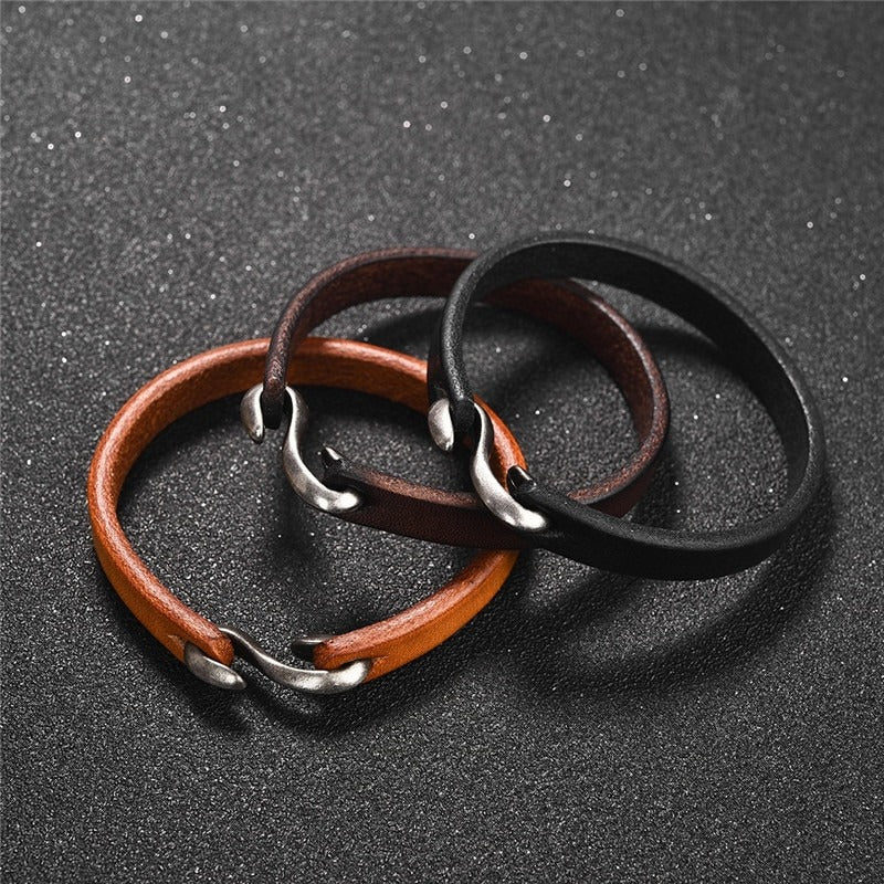 Set of three vintage leather bracelets for men and women in black, brown, and tan with stylish metal clasps.