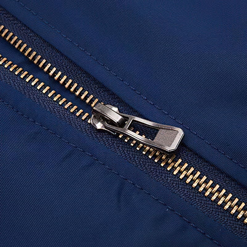 Close-up of a thick zipper on a men's oversized padded jacket in navy color for a trendy casual streetwear look.