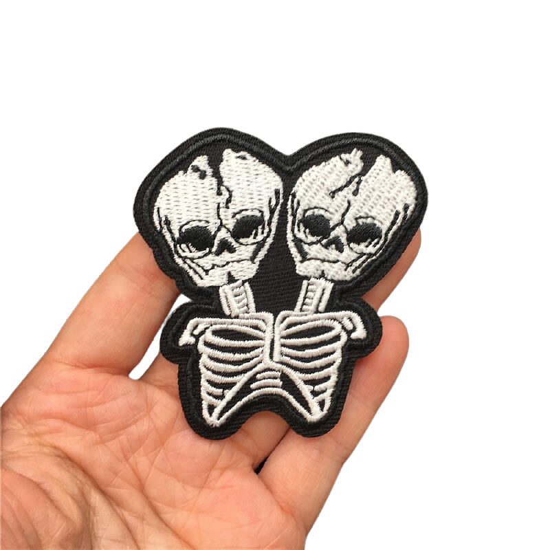 Two-headed skeleton alien patch held in hand, perfect gothic accessory for unisex clothing styles.