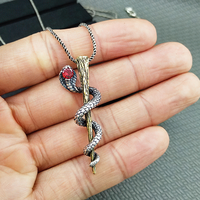 S925 sterling silver pendant depicting a detailed cobra wrapped around a stick, with a red gemstone accent.