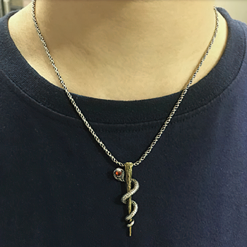 Sterling silver cobra pendant necklace showcased on a person, highlighting unique alternative jewelry style.