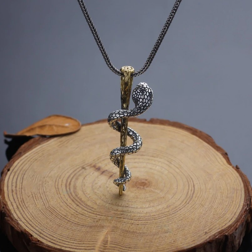 S925 sterling silver cobra pendant on a wooden surface, showcasing intricate detail and an alternative style.